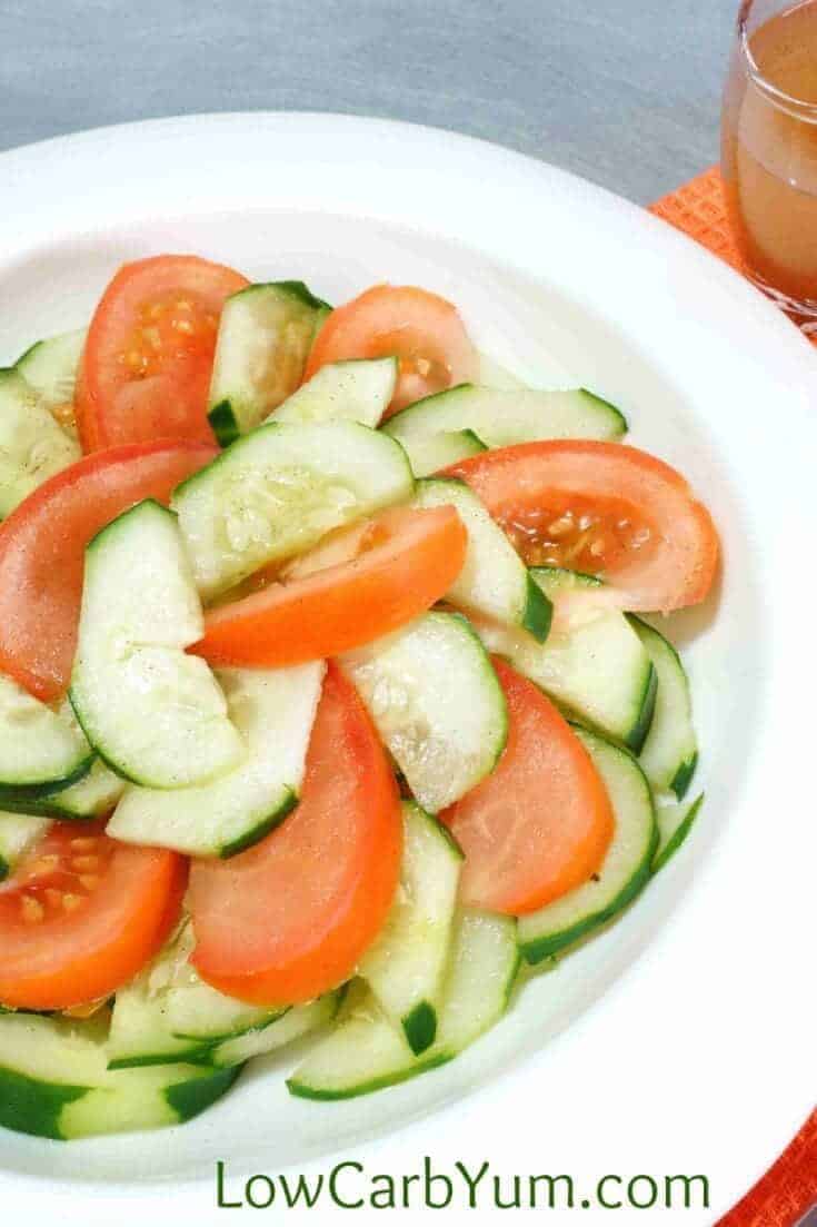 cucumbers and tomatoes are sliced and tossed in a keto dressing