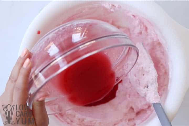 adding raspberry liquid to whipped cream