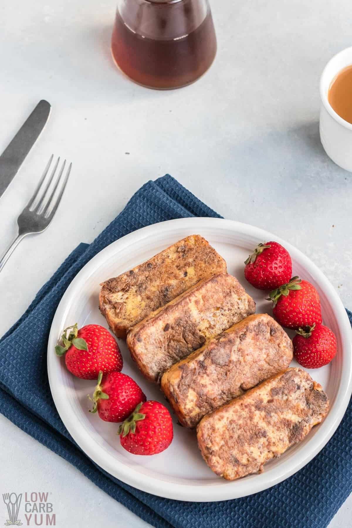 four slices of low-carb french toast on white plate with strawberries