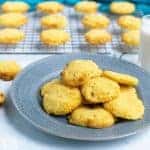 coconut flour cookies on plate with more on cooling rack