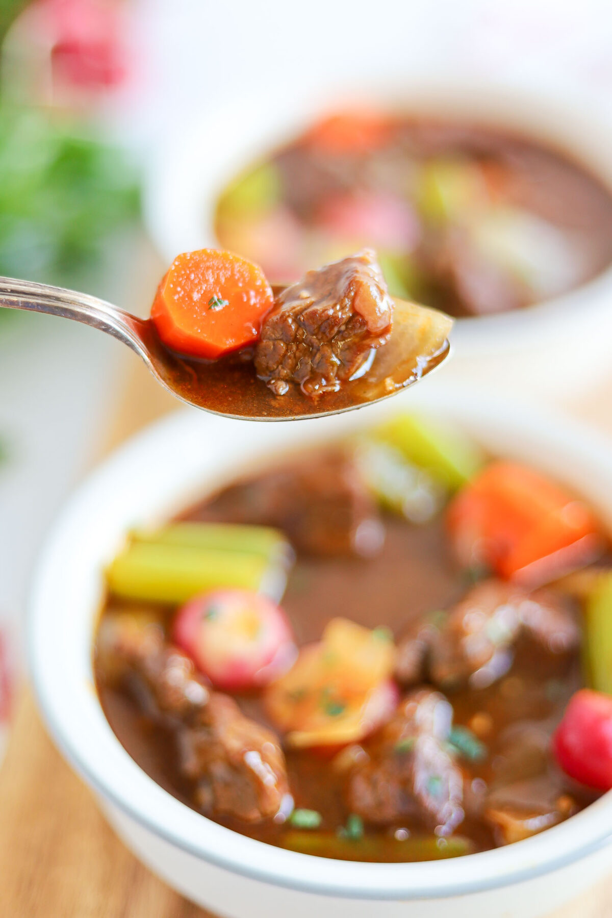 eating a spoonful of beef and carrots soup