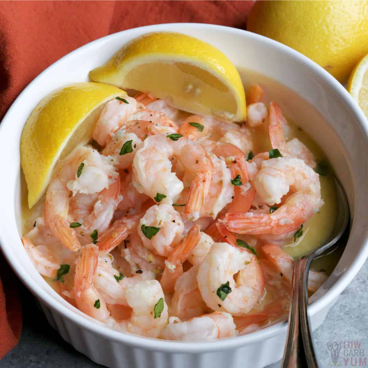 crock pot shrimp scampi in bowl with lemon wedges featured image.
