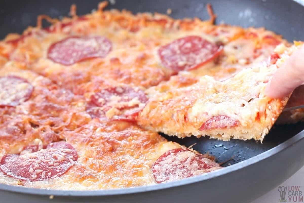 baked keto pizza with slice being removed