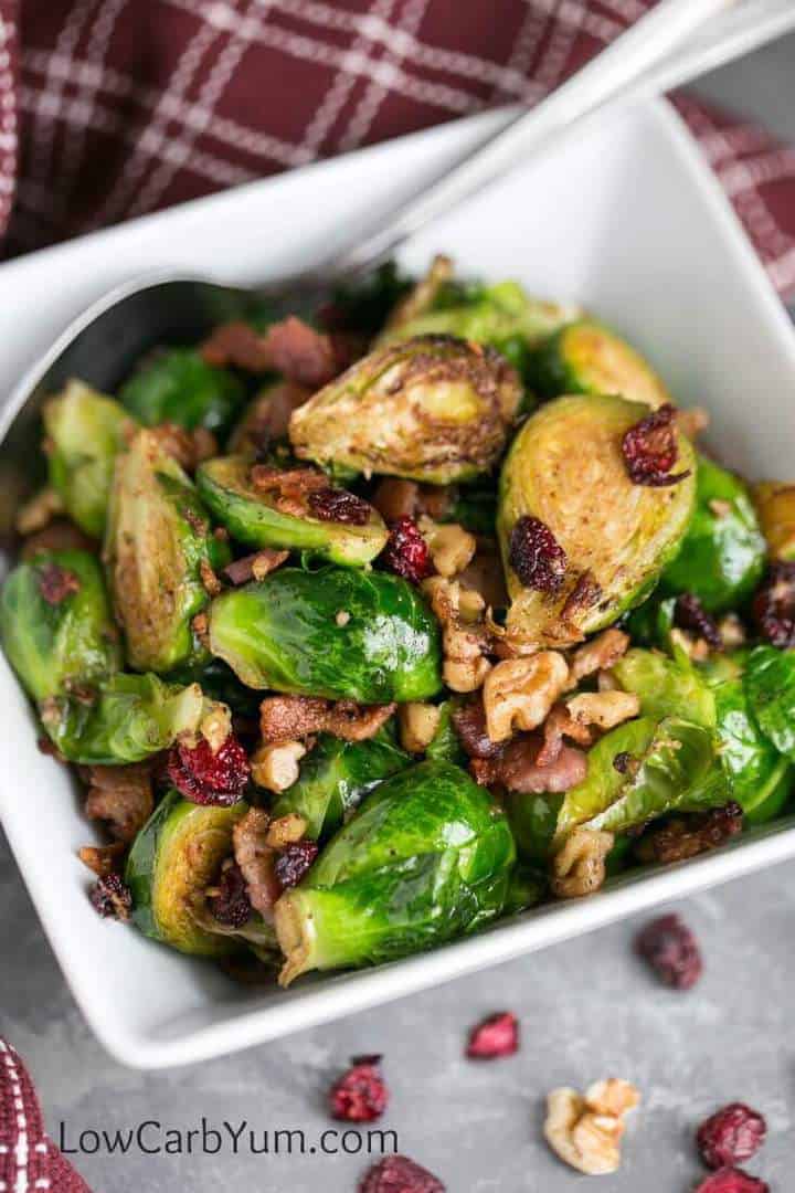 Pan fried keto brussels sprouts are paired with bacon cranberries walnuts