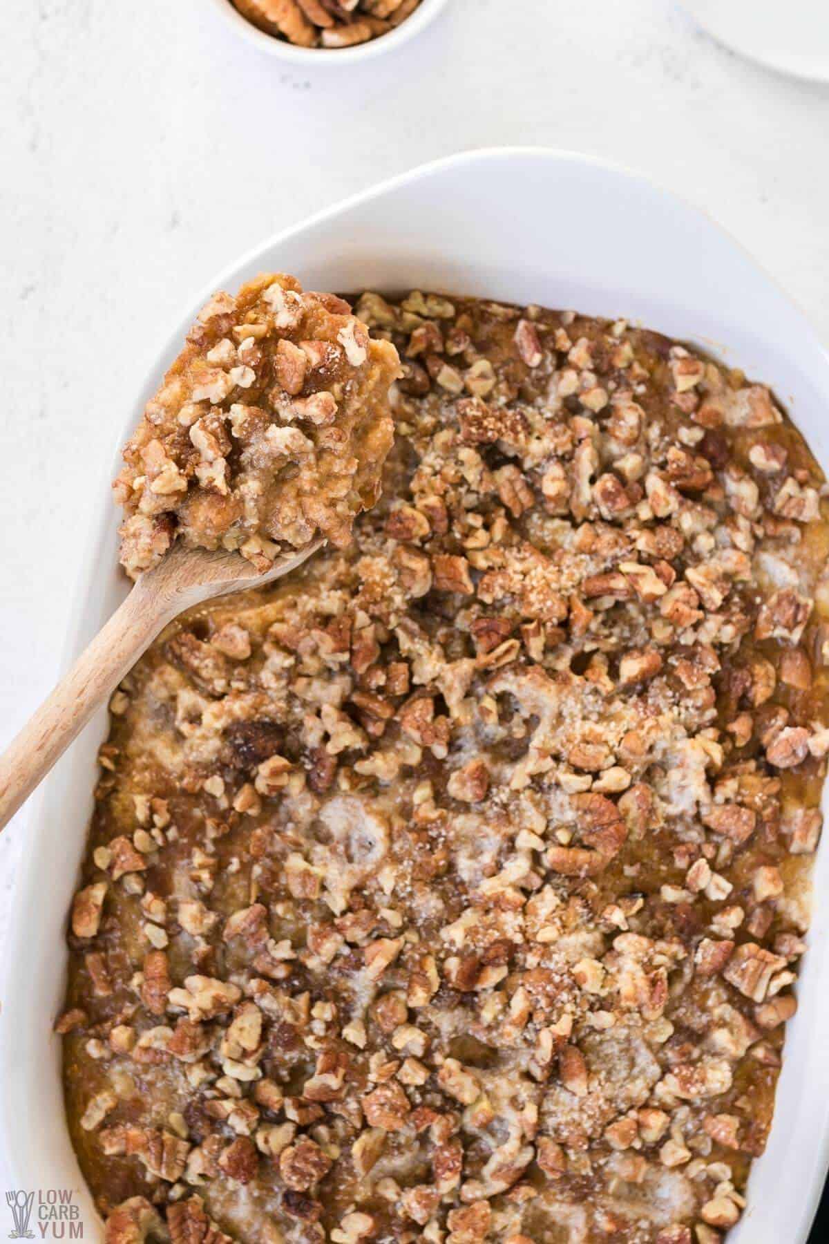 keto sweet potato casserole in baking pan with spoon tall image