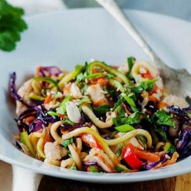 peanut chicken zucchini noodles in bowl with fork