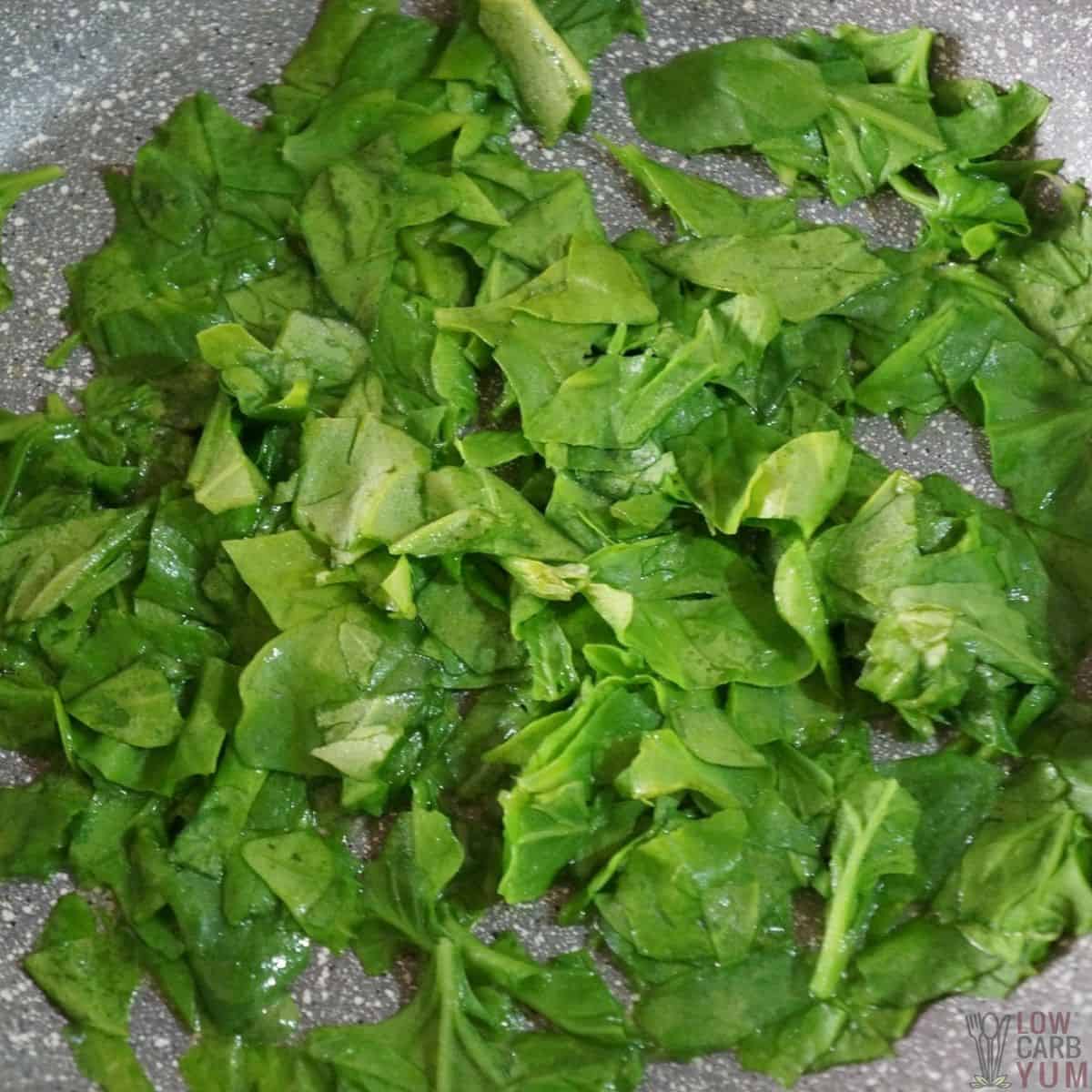 wilting spinach in skillet.