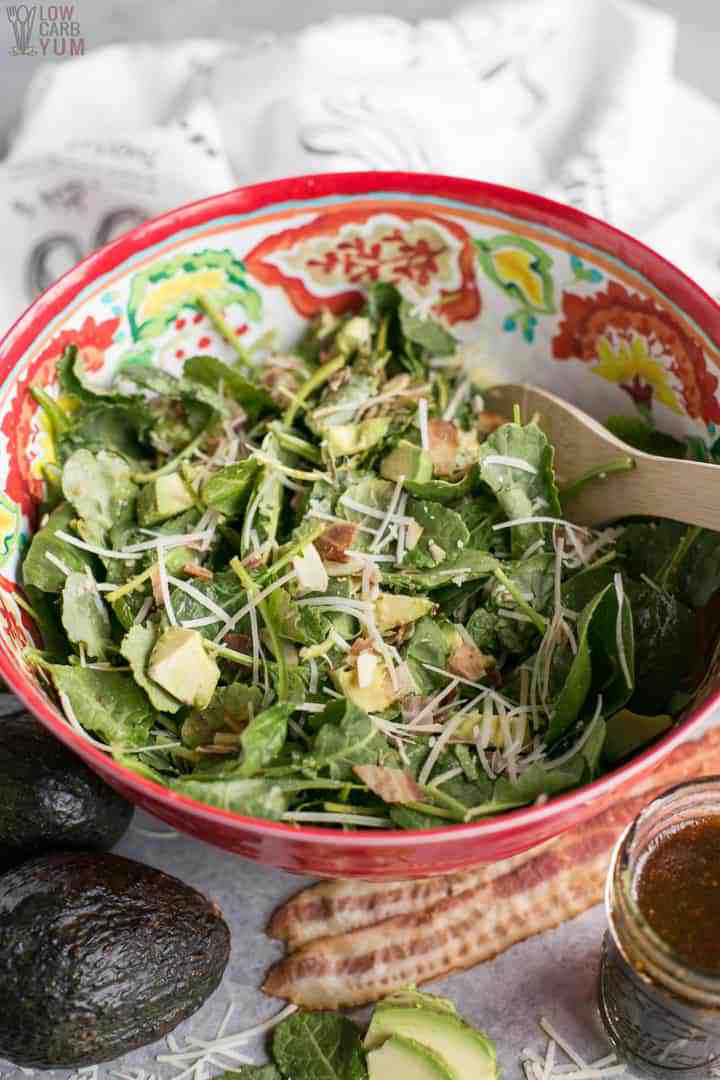 Big bowl of baby kale avocado salad with parmesan cheese