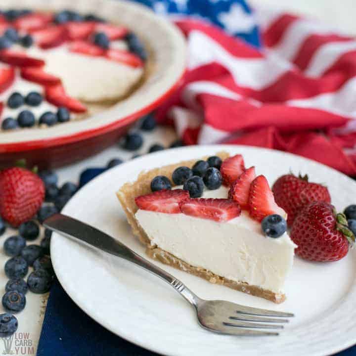 Slice of keto low carb no bake cheesecake on white plate with fresh berries