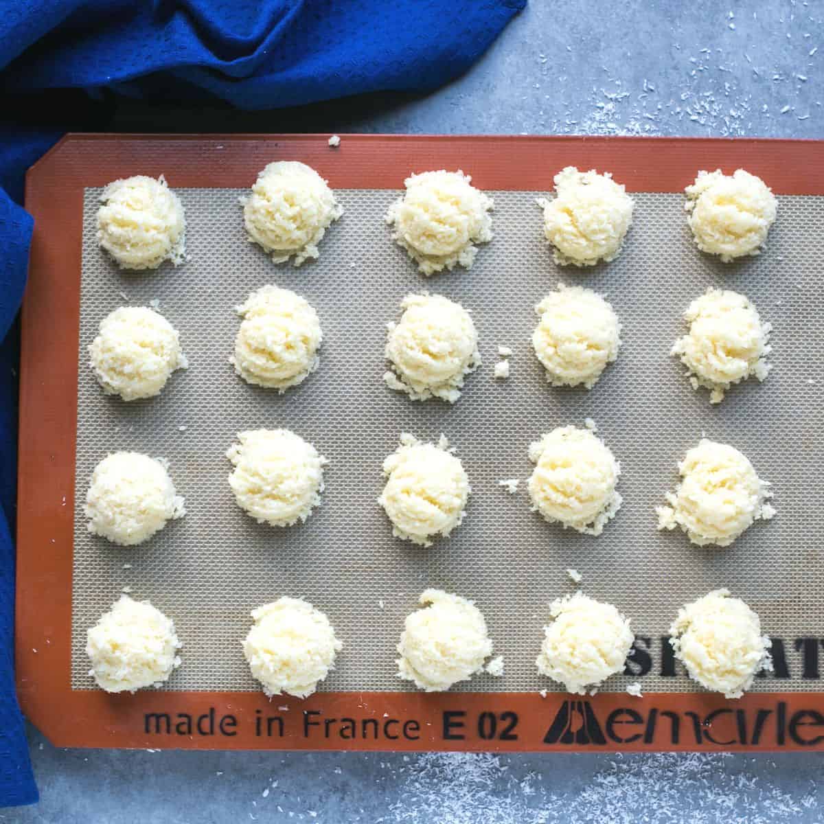 dough balls on silicone mat lined cookie sheet.