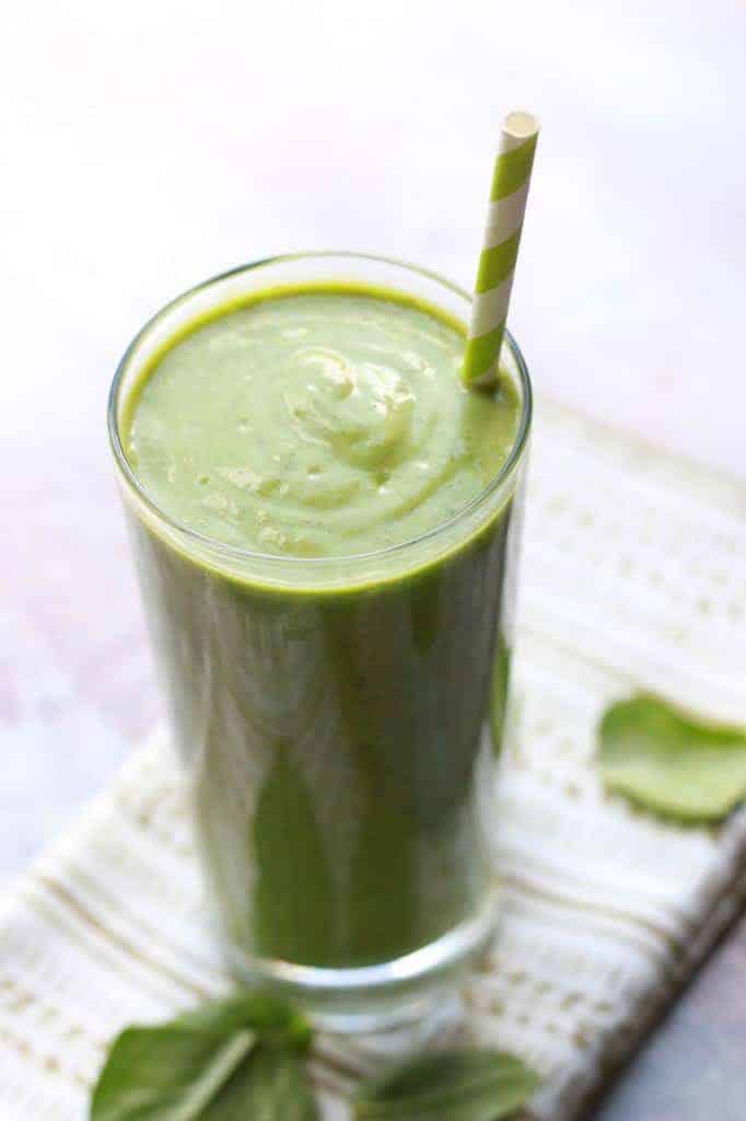 Green Smoothie in glass with green and white striped paper straw