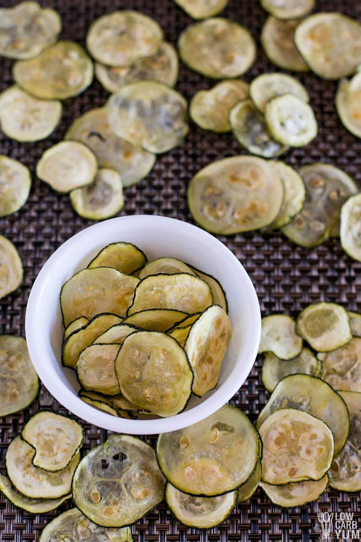 zucchini chips in white bowl and on placemat.