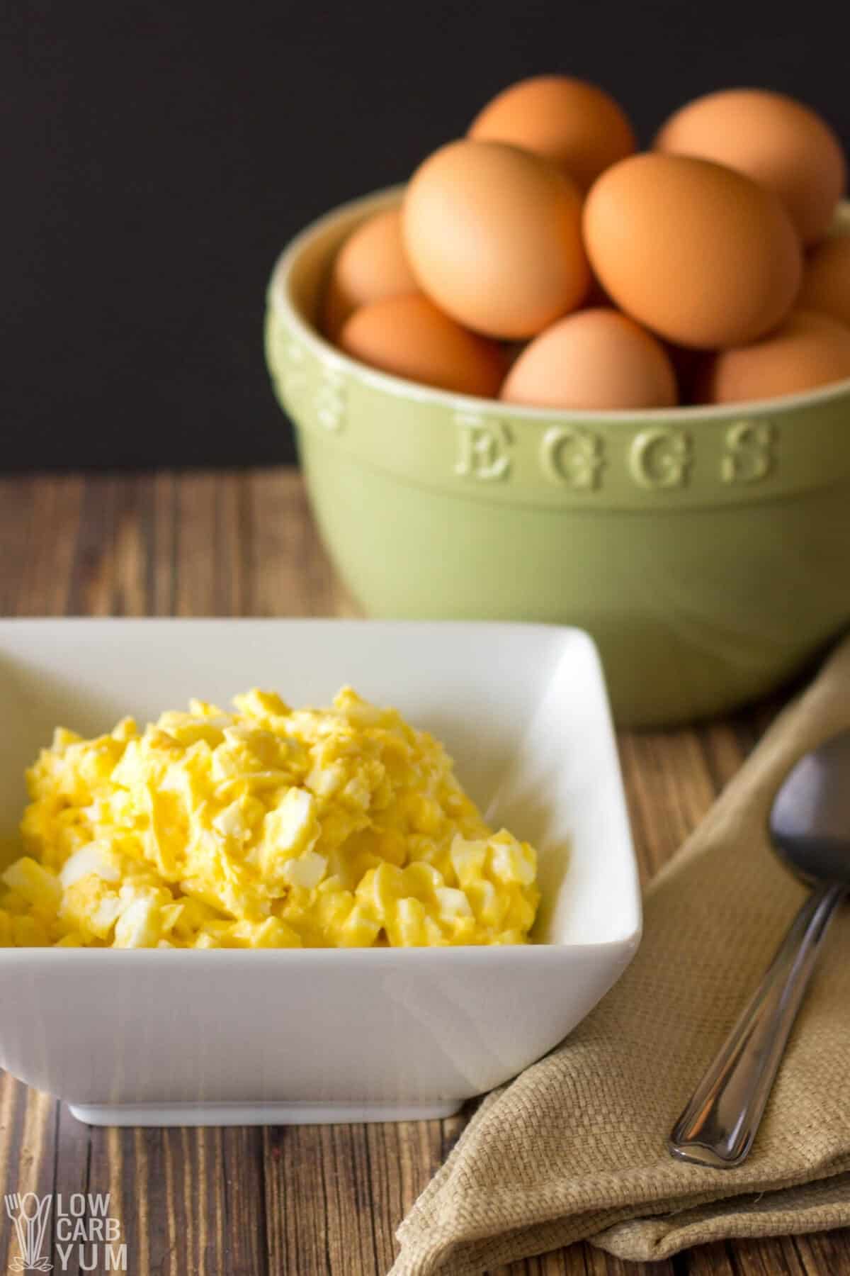 egg salad keto in bowl with eggs behind