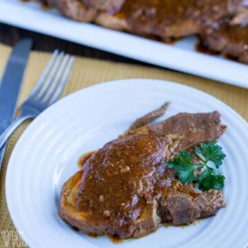 Instant Pot Pork Chops on white plate and fork and knife