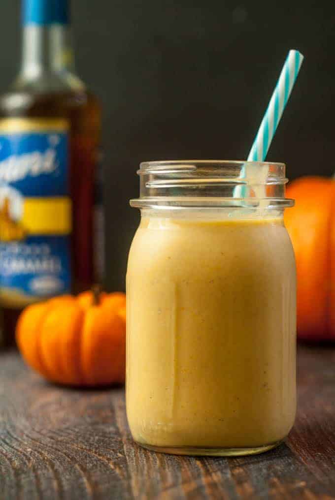 low carb smoothie in a tall glass jar with blue and white striped straw