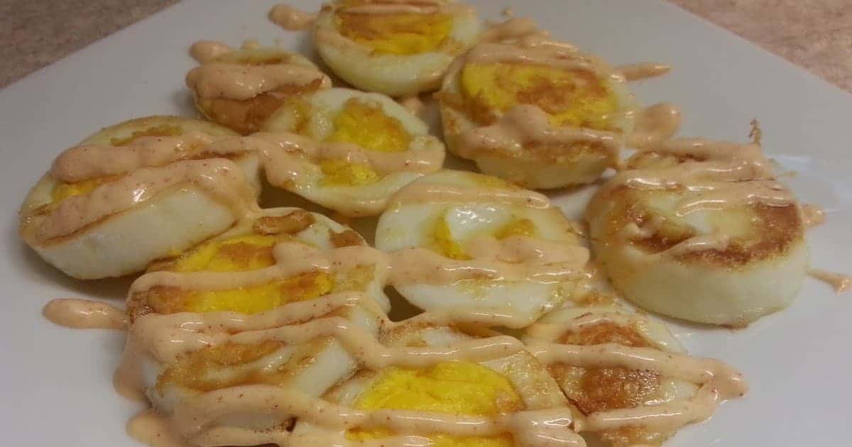 Cut Hard-Broiled Eggs with yum yum Sauce Drizzled on it on plate
