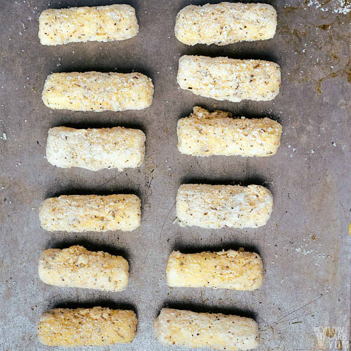frozen prepared cheese sticks on baking sheet.