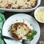 overhead shot of spaghetti squash lasagna on white plate with casserole dish