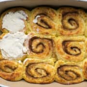 keto cinnamon rolls in pan with cream cheese frosting