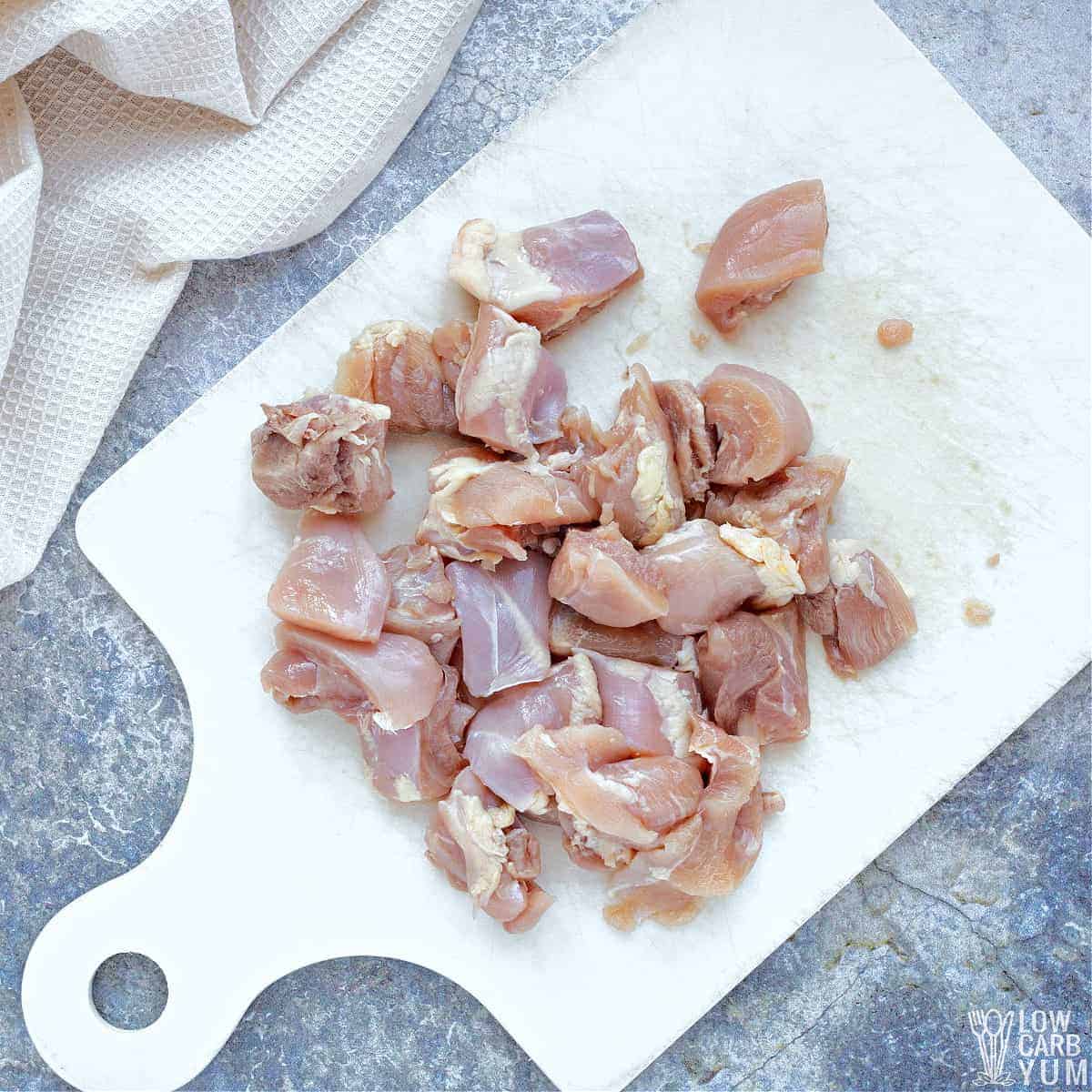 cut chicken on white cutting board.