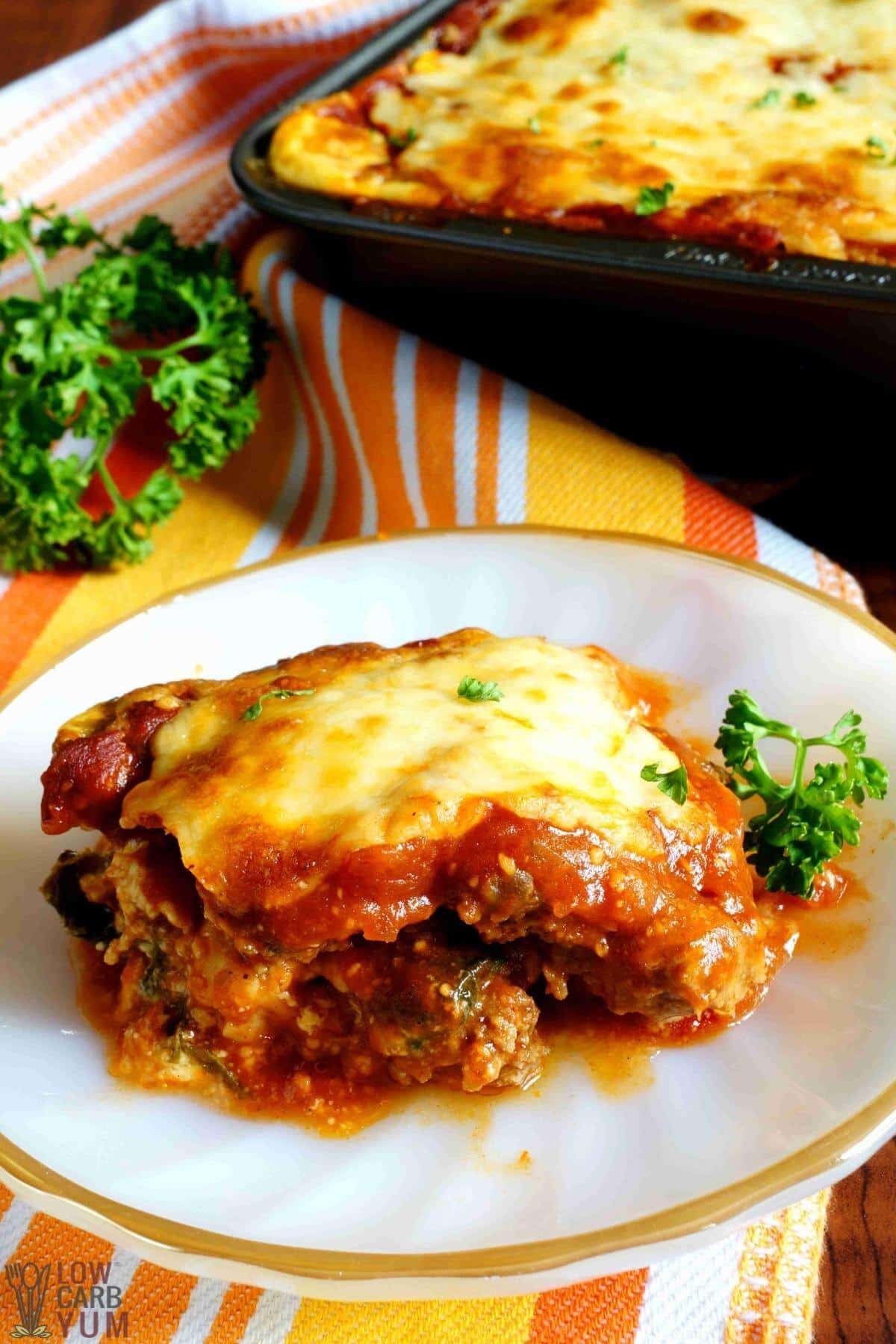 serving keto lasagna on small white plate