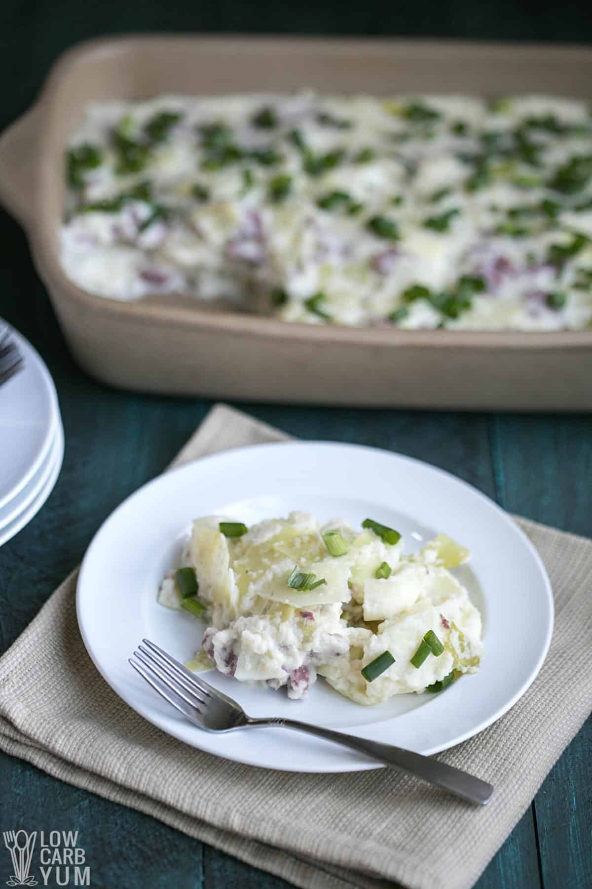 keto corned beef casserole with cabbage on white plate and in stoneware pan