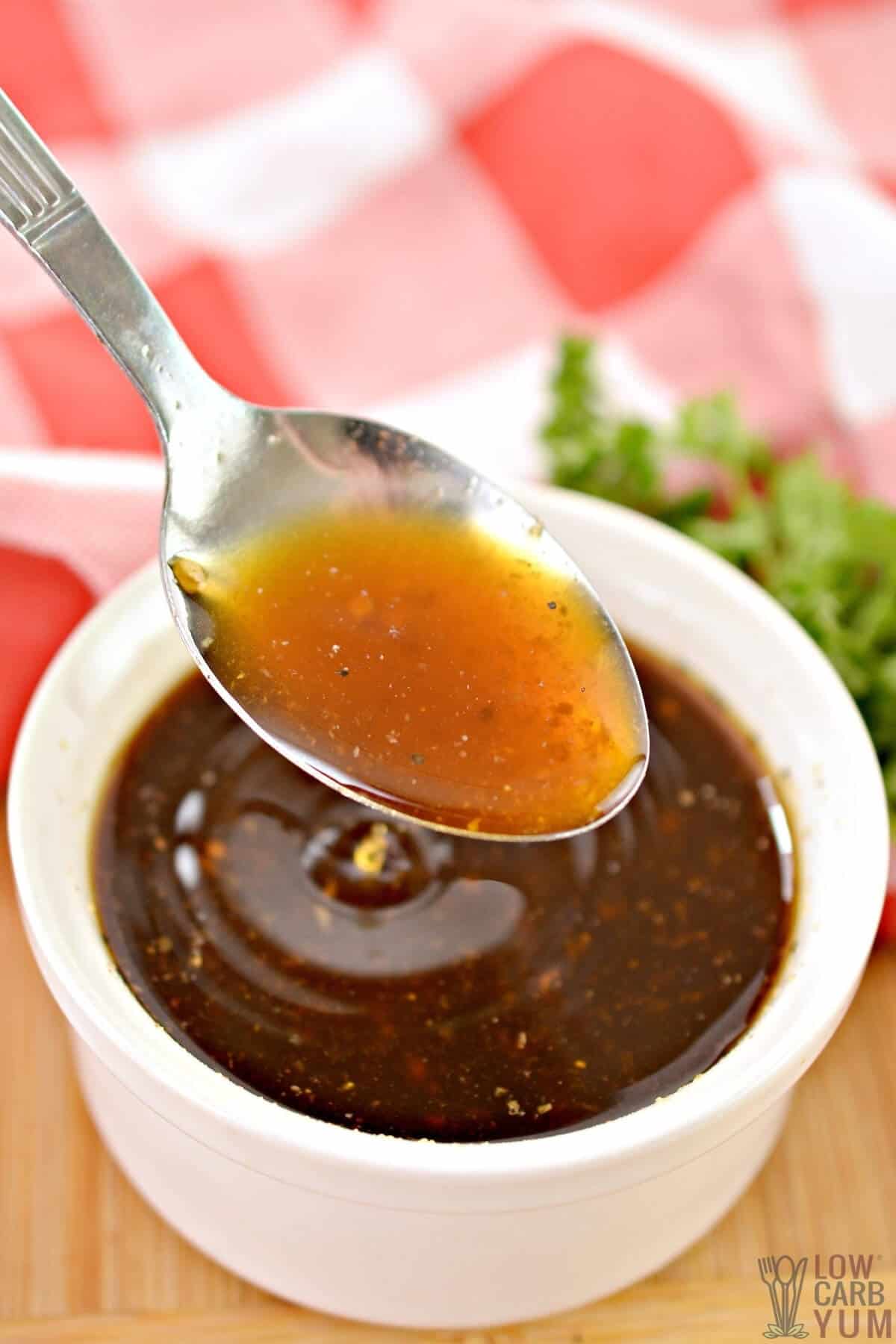 spoon of sauce over cup of whisked ingredients