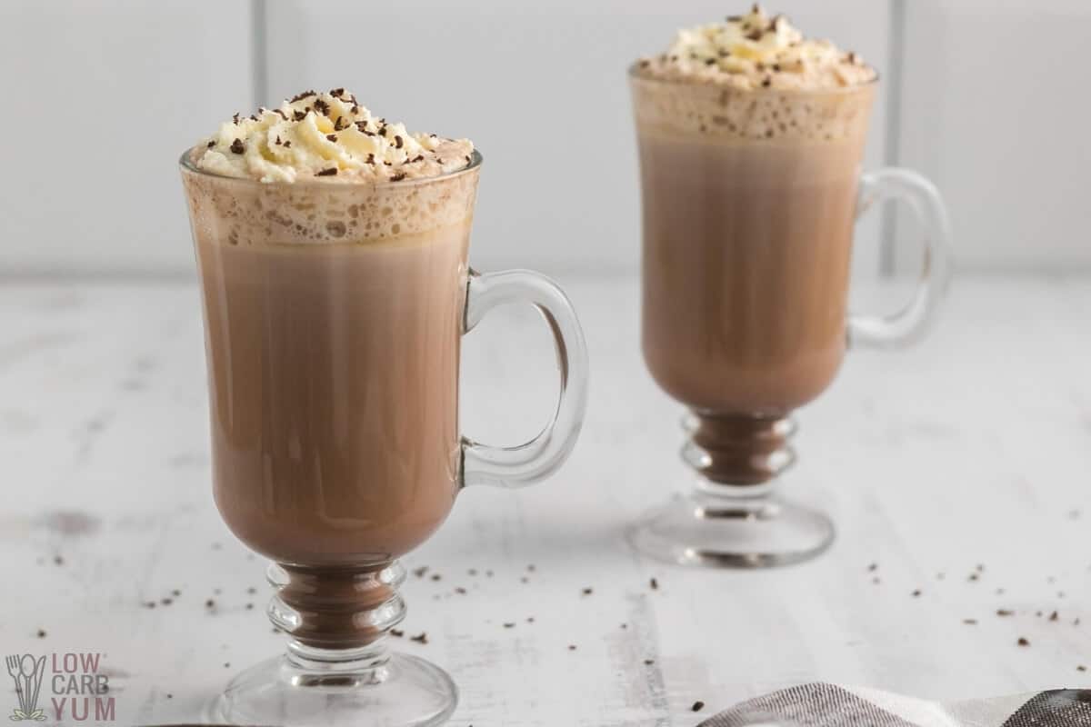 two glasses of sugar free low carb hot chocolate with whipped cream and grated chocolate