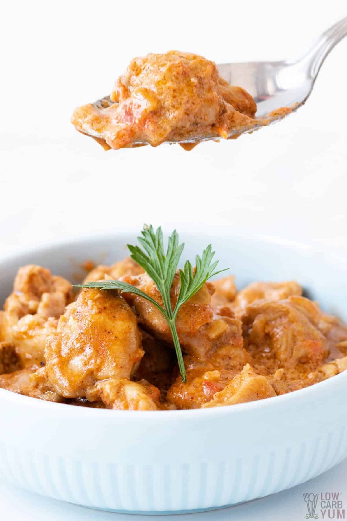 butter chicken keto in bowl with spoon above