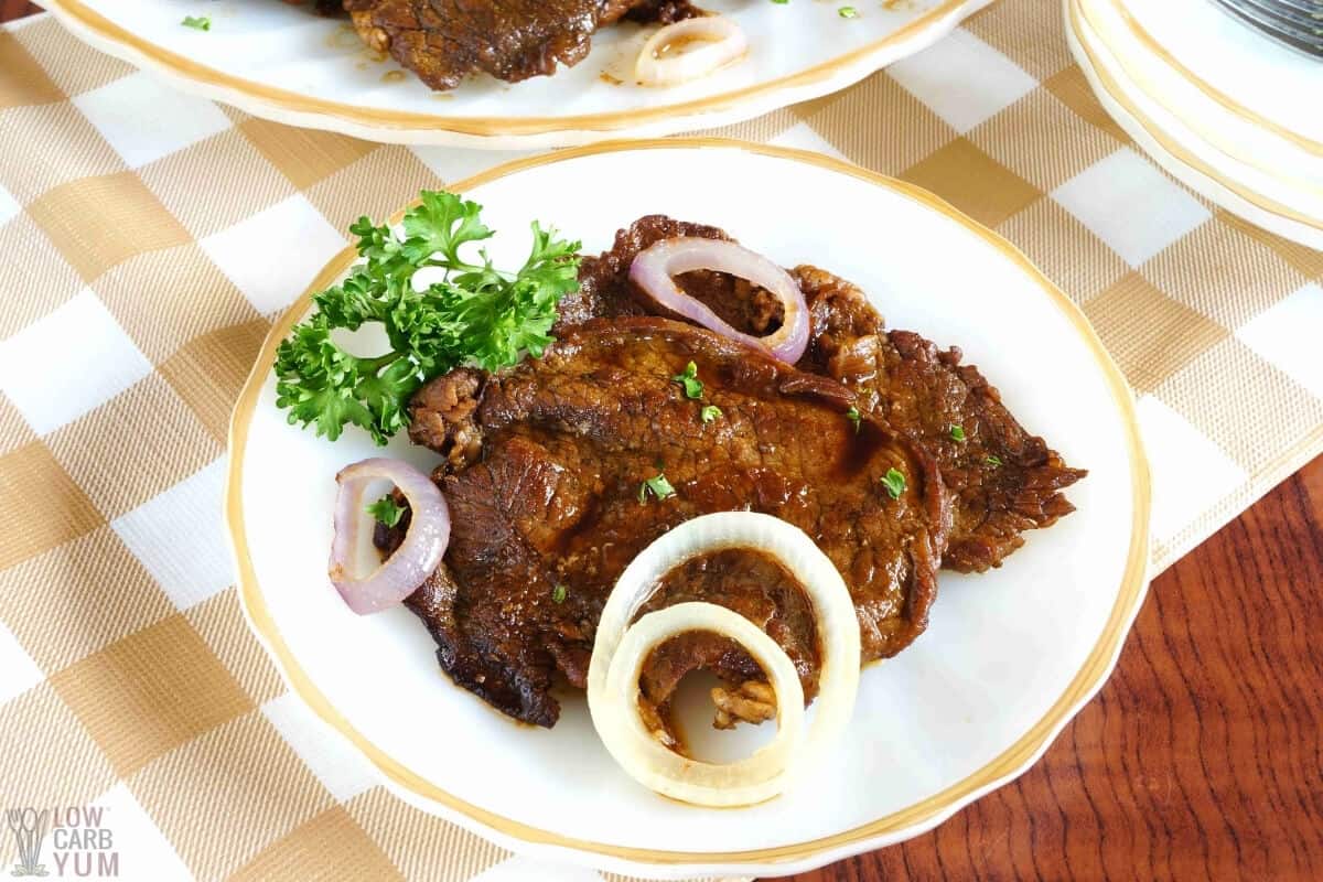 filipino beef steak on white plate with sliced onions 