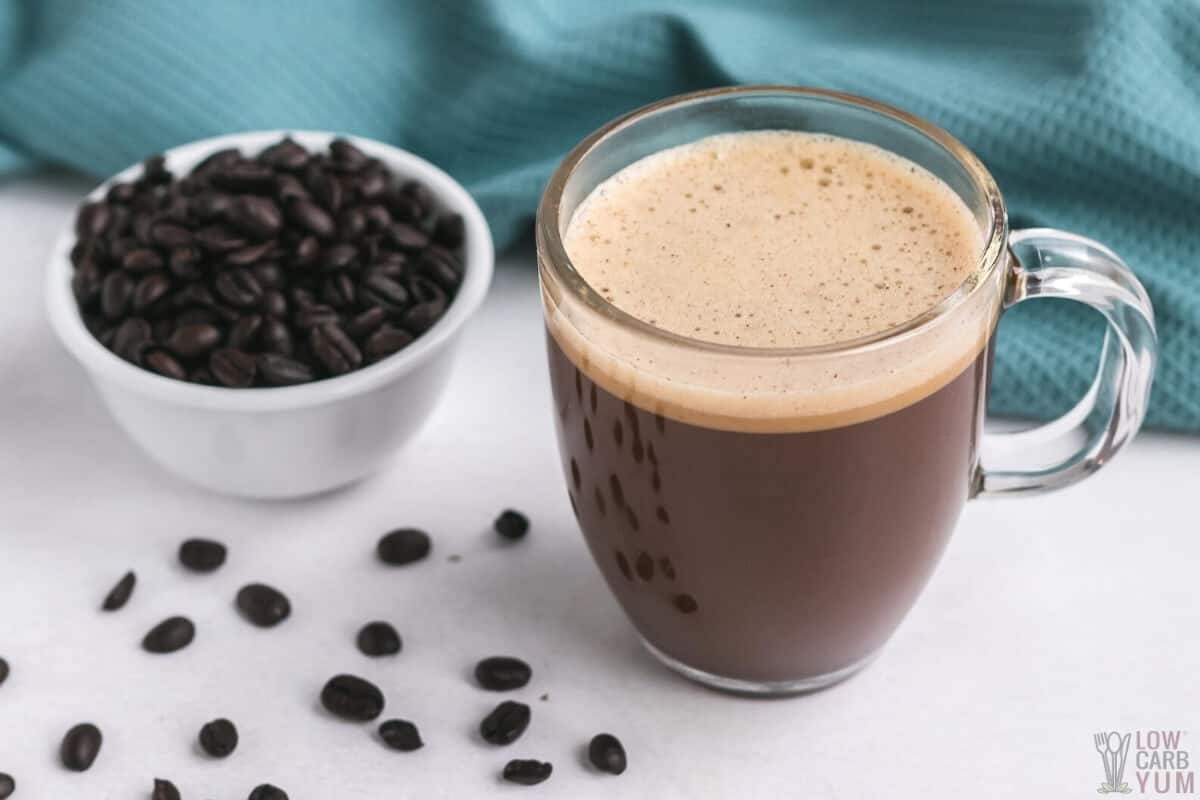 homemade bulletproof coffee in glass cup with coffee beans