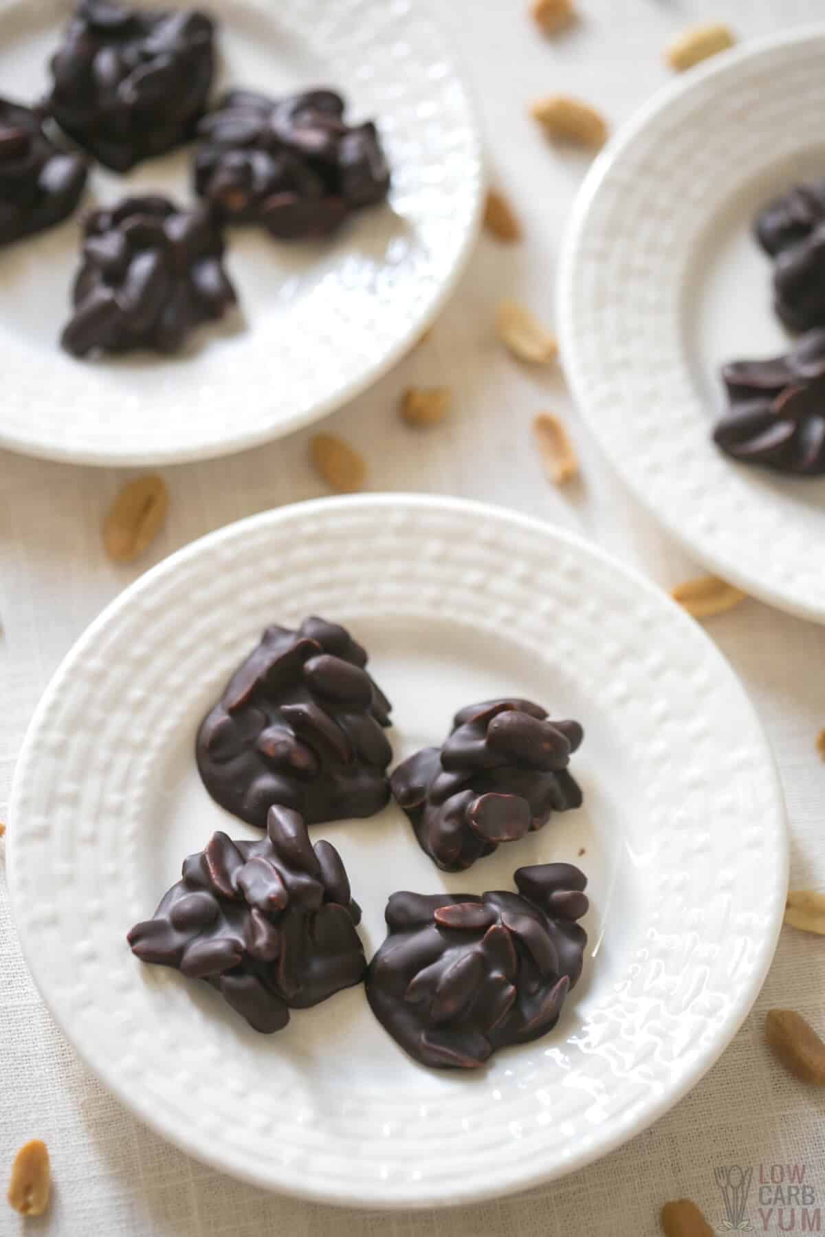homemade chocolate peanut clusters on white plates