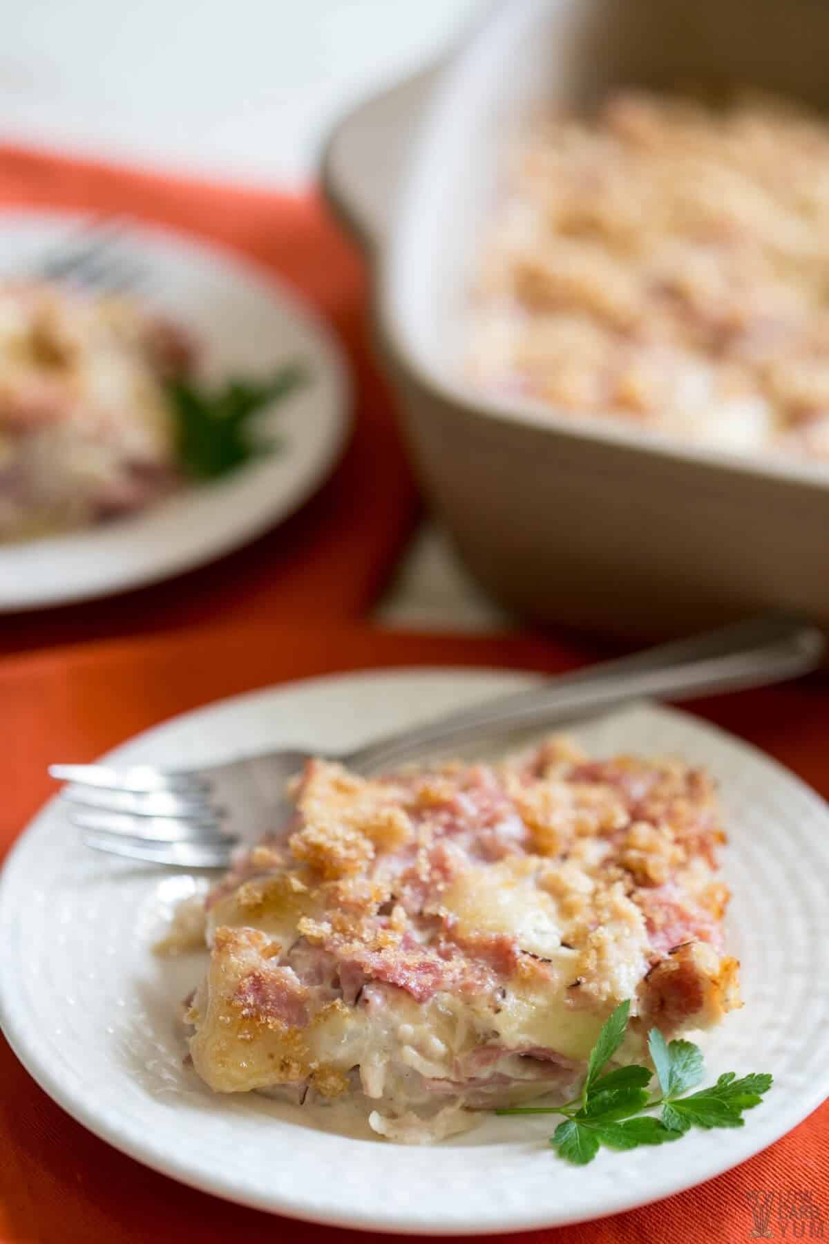 chicken cordon bleu slice on plate with casserole dish in back