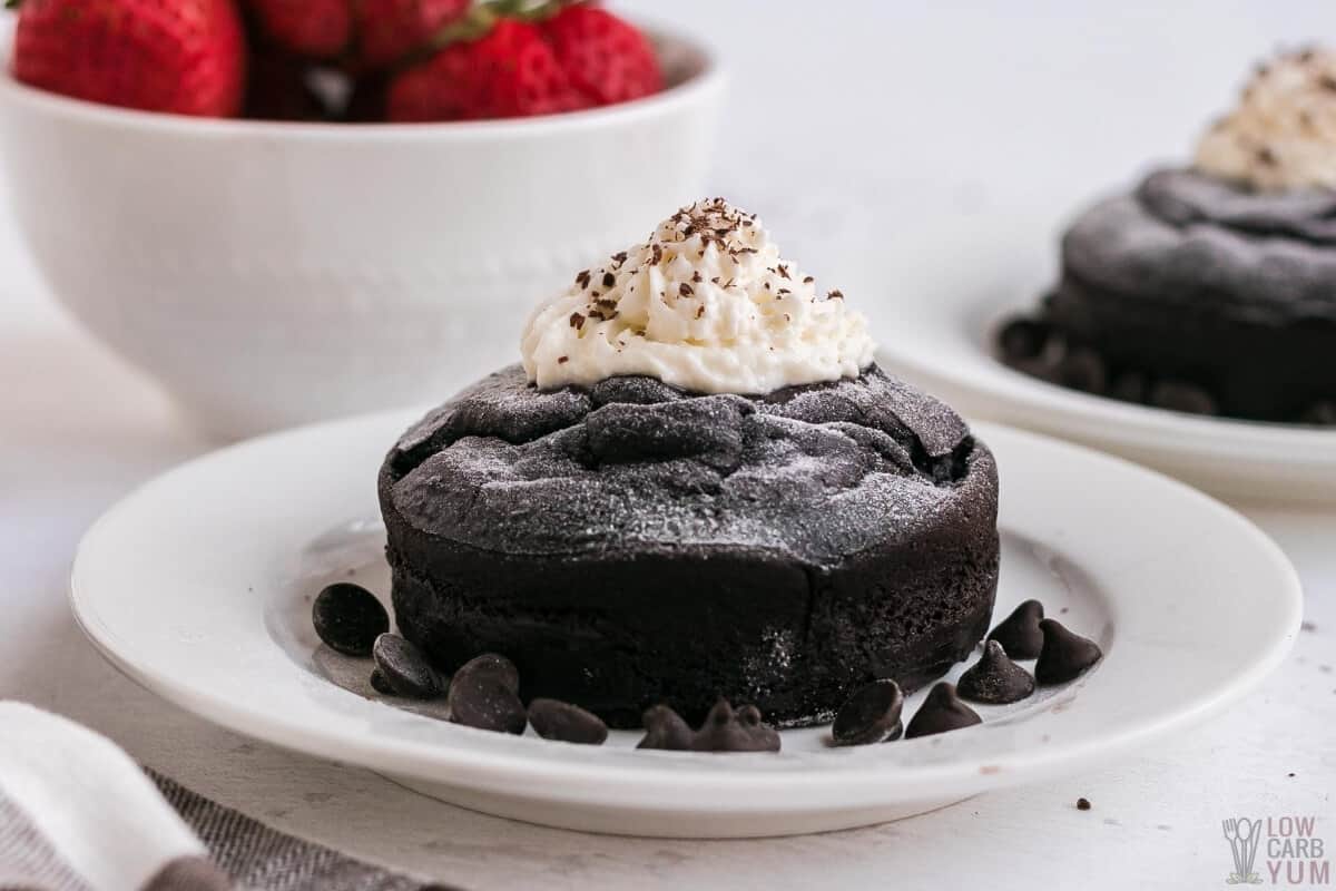 keto molten lava mug cakes on plates with strawberries