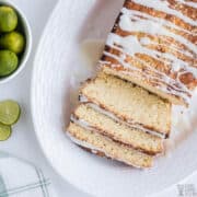 sliced key lime bread on platter with limes