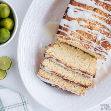 sliced key lime bread on platter with limes
