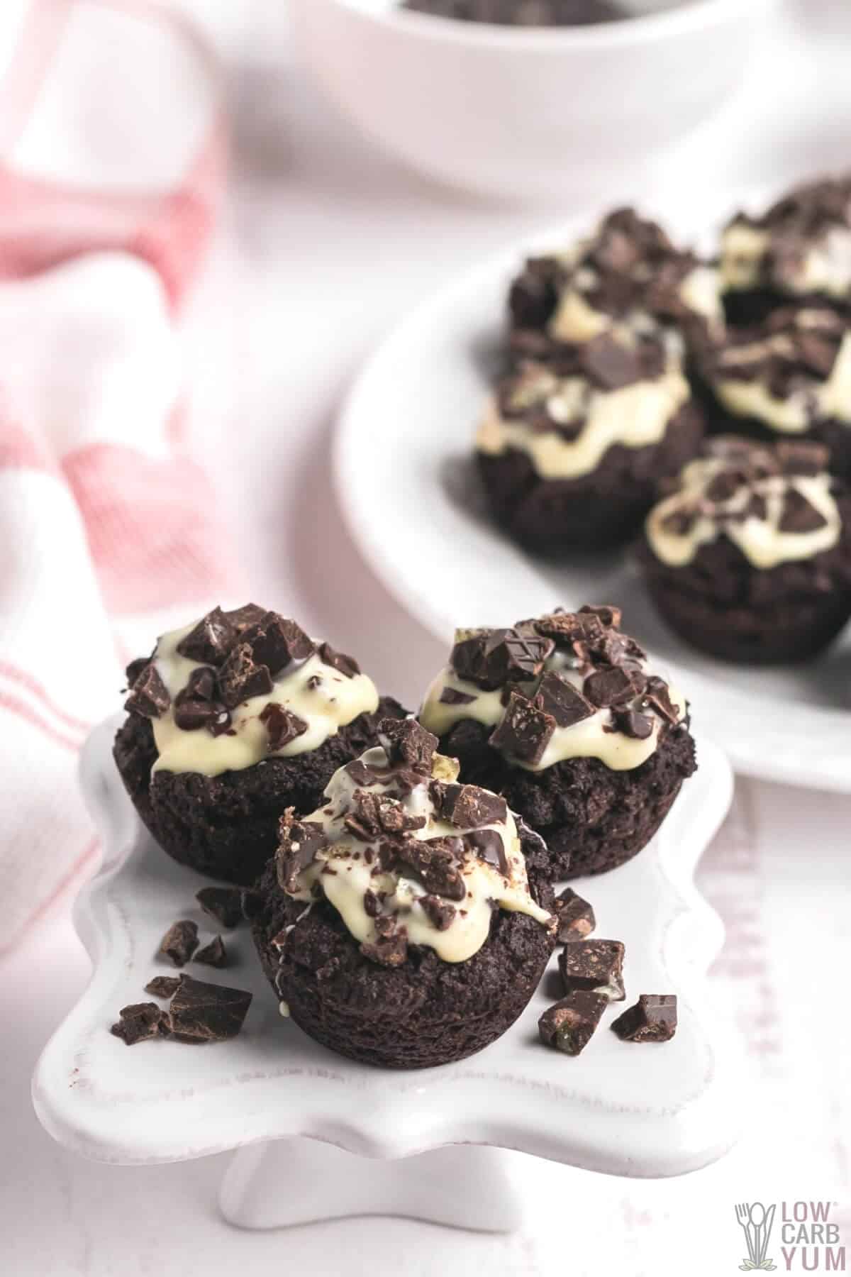 almond flour brownie bites are iced and covered in chocolate chunks