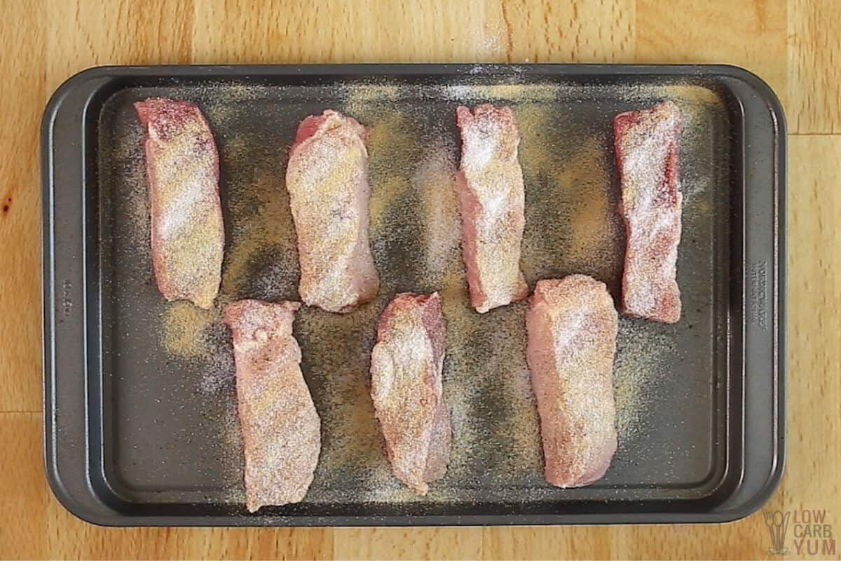 seasoned boneless pork ribs on baking sheet