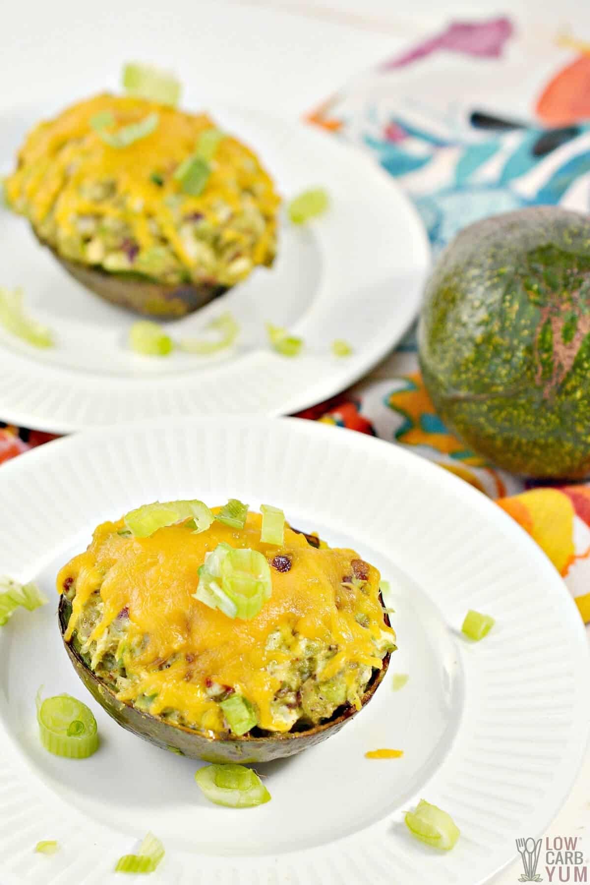 chicken stuffed baked avocado on white plates