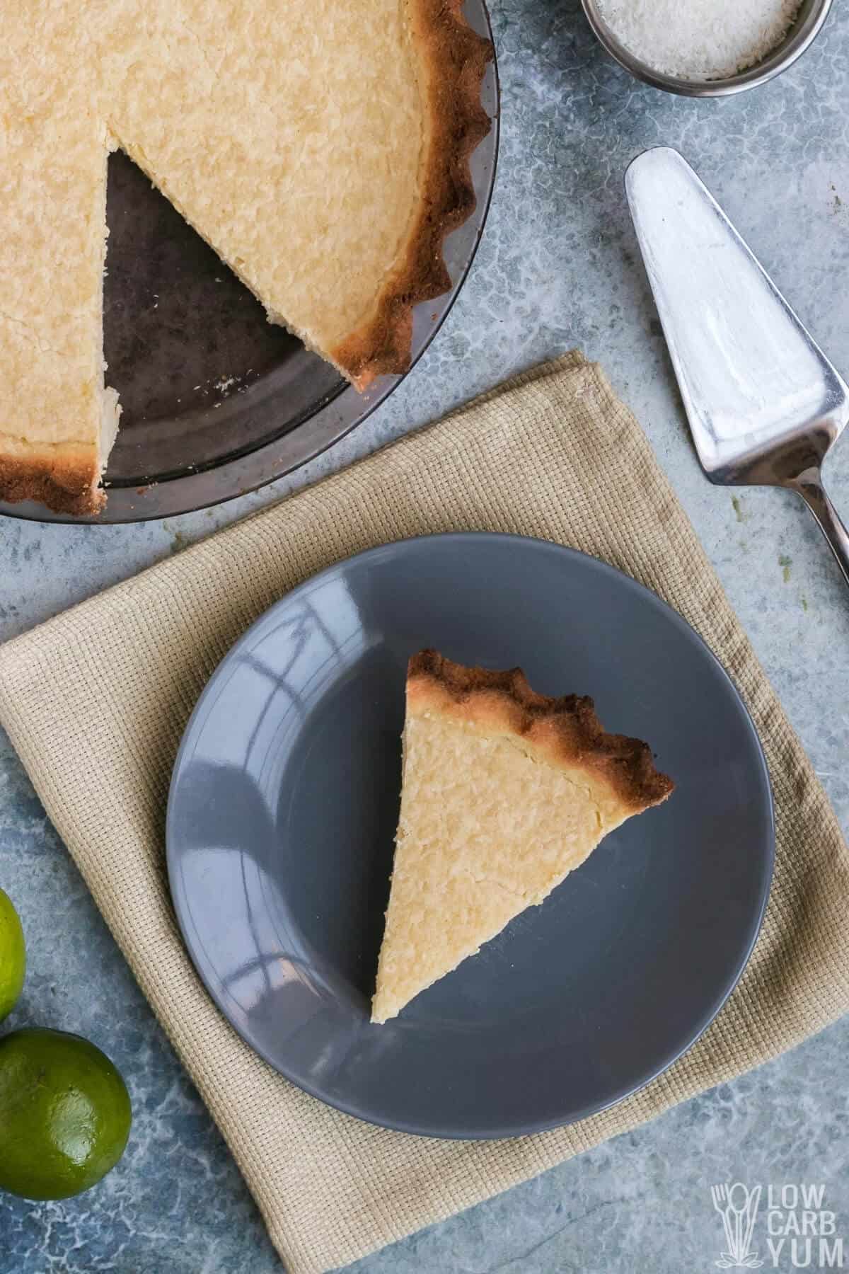 sliced coconut key lime pie with slice on gray plate