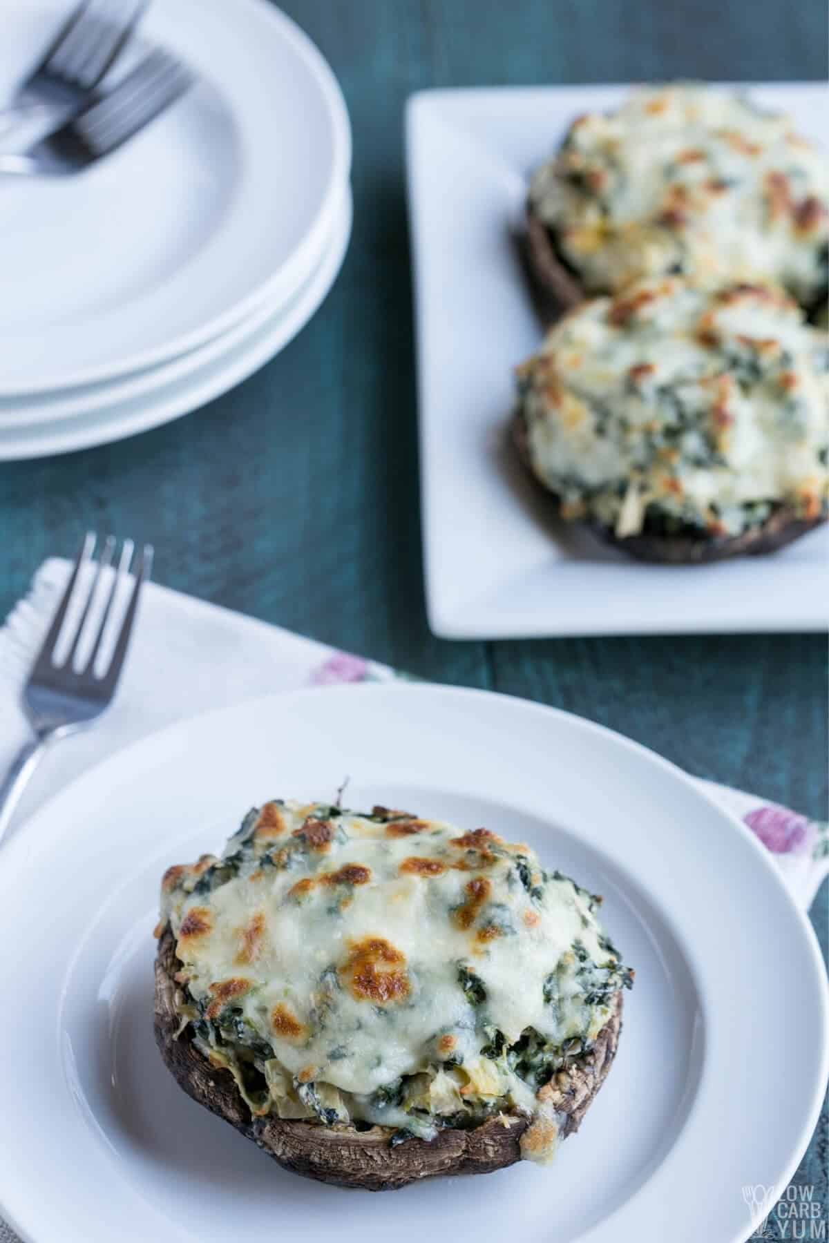 portobello mushrooms are stuffed with keto friendly cheese and veggies and served on plates