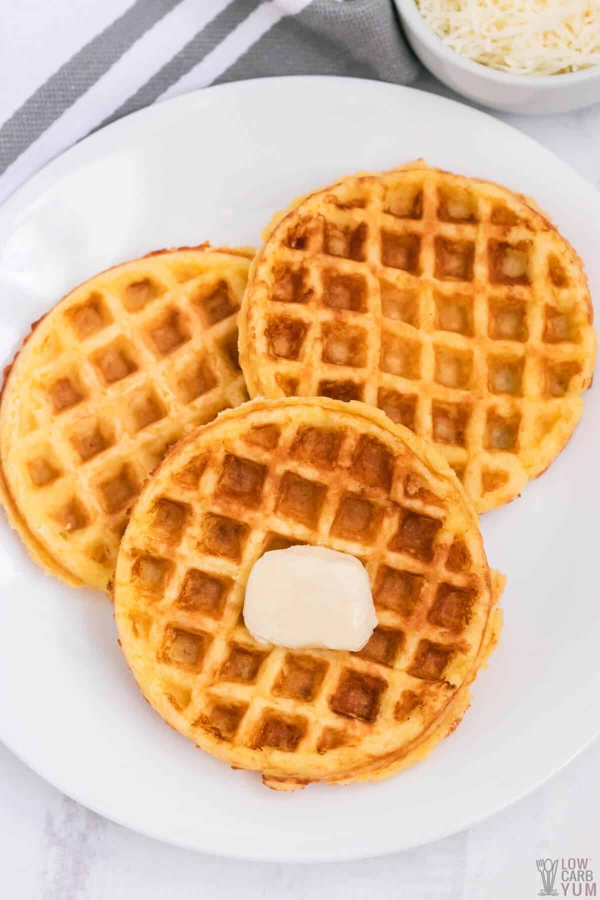 three chaffles on white plate with pat of butter