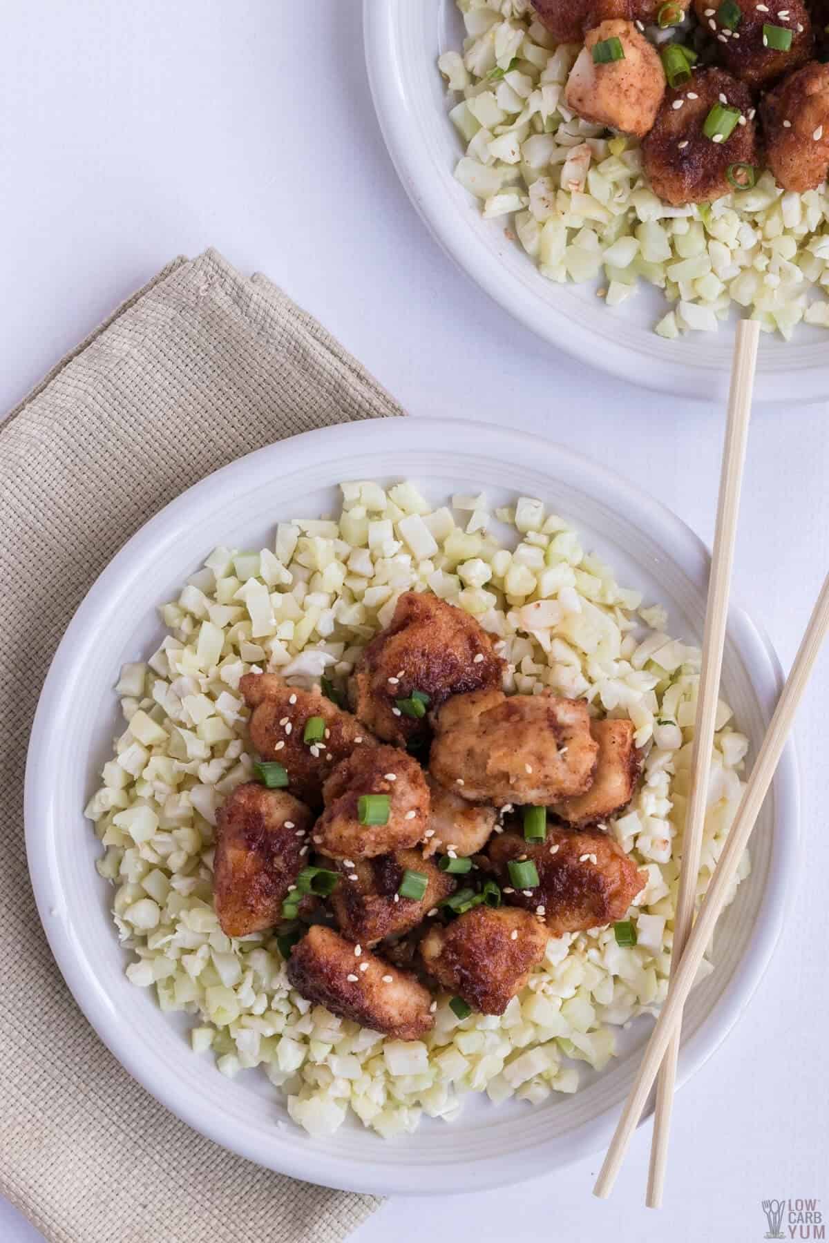 overhead of keto sweet and sour chicken over cauliflower rice on plates