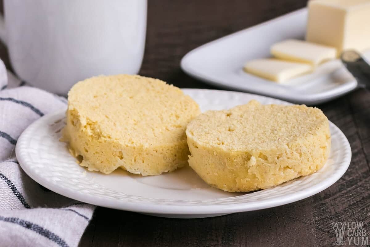 close up of muffin slices on white plate with mug and butter