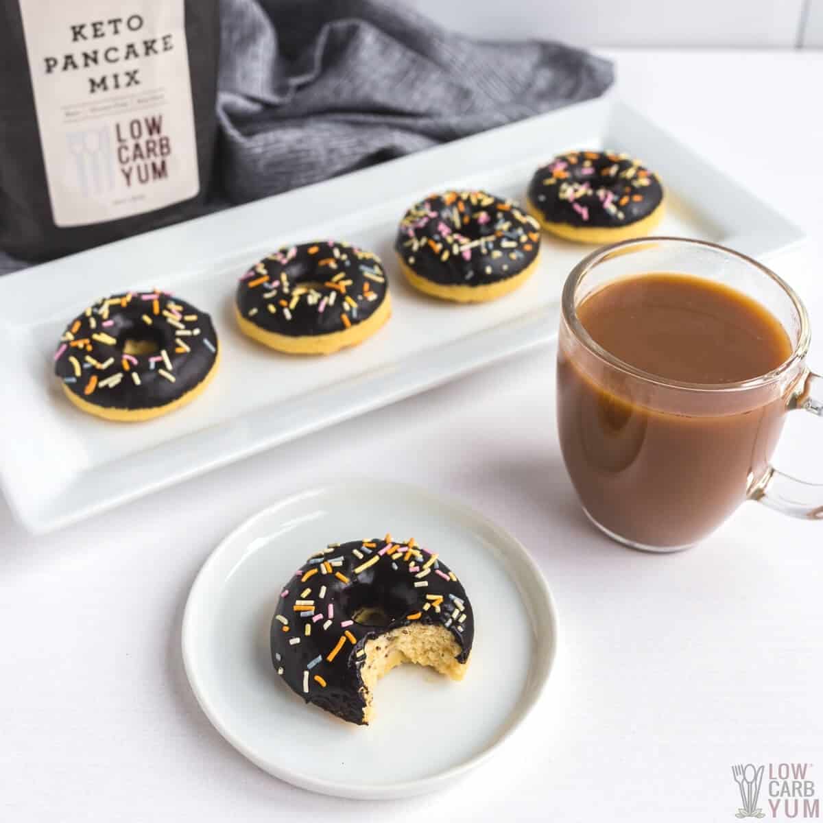 donut with bite on white plate with coffee