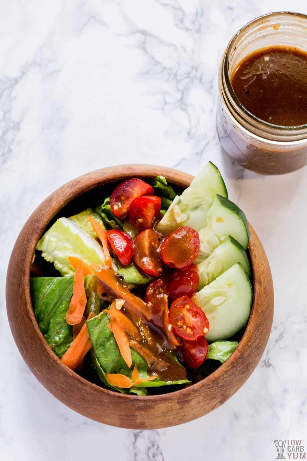 balsamic vinaigrette dressing on salad in wood bowl