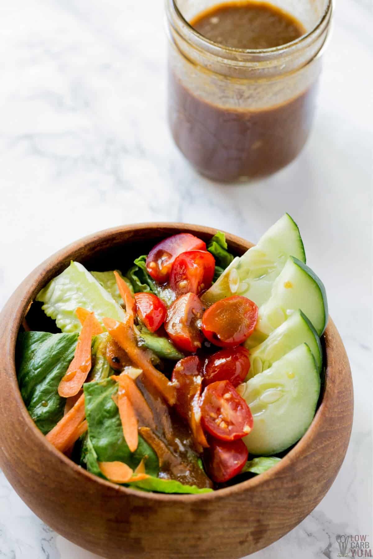 keto balsamic vinaigrette salad dressing over vegetables in wood bowl
