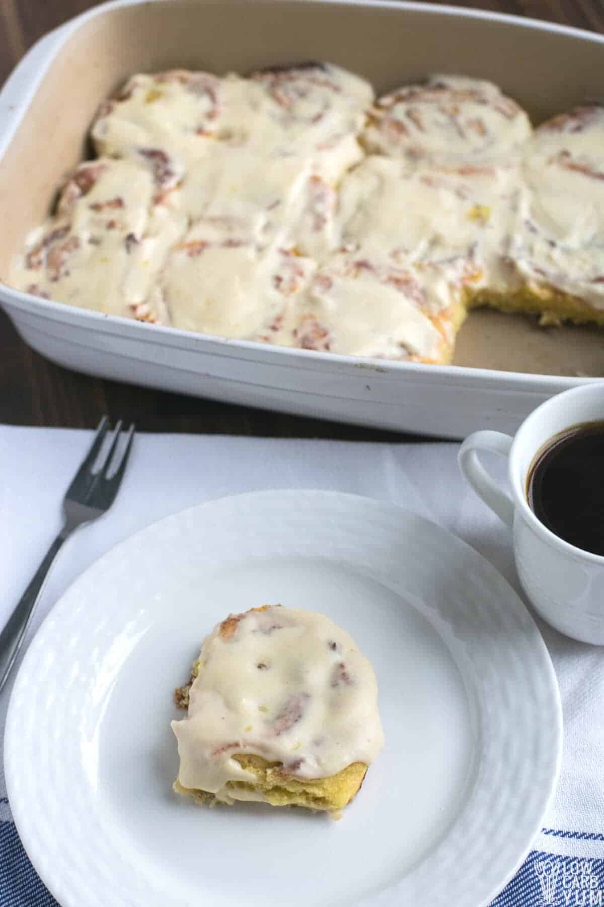 cinnamon rolls in casserole pan and on white plate with coffee