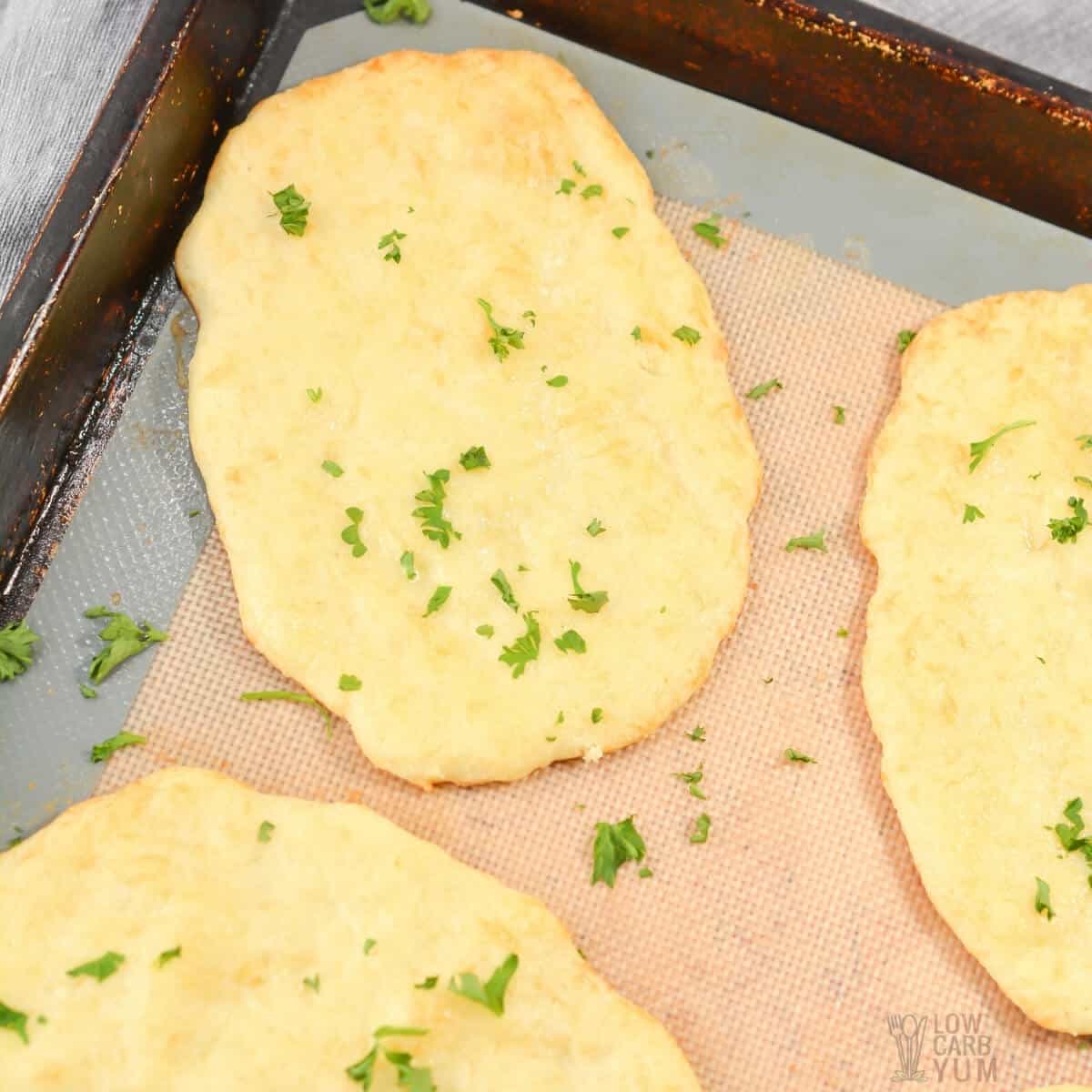 baked keto naan bread on lined baking sheet