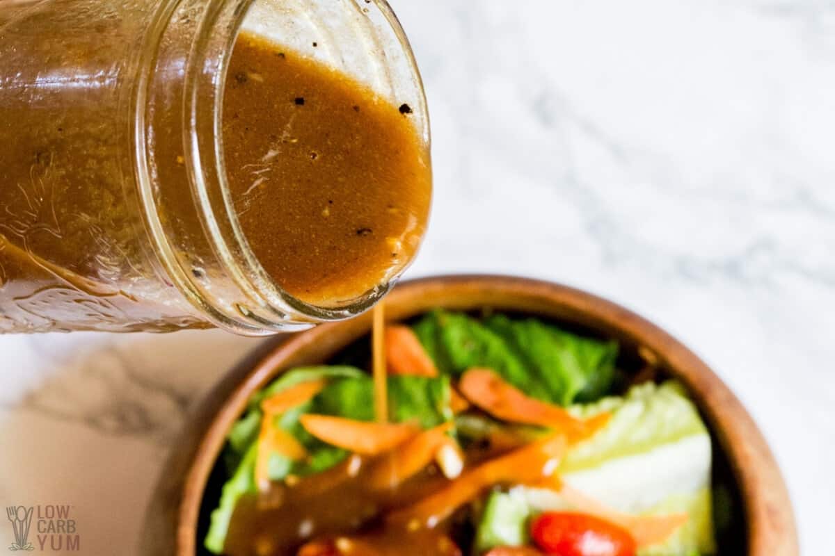 pouring balsamic vinaigrette dressing onto salad